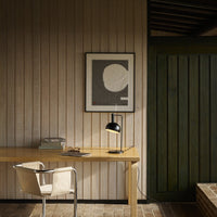 Modern home office with wooden desk, chair, and wall art.