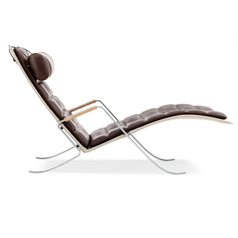"Modern brown leather chaise lounge with subtle tufted pattern and sleek chrome accents."