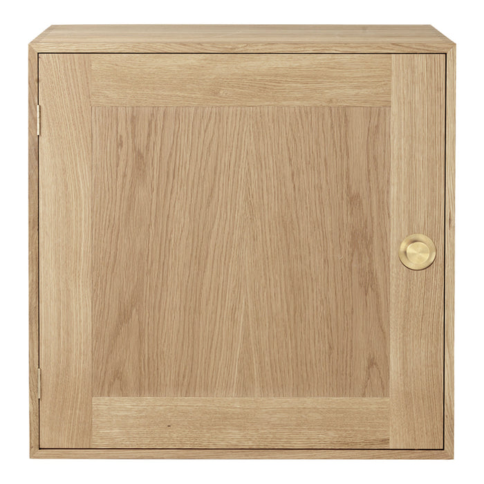 Minimalist oak cabinet with a natural wood finish and subtle grain pattern, featuring a sleek brass knob.