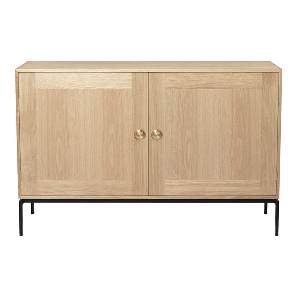 Natural oak wood cabinet with minimalist design, featuring a smooth grain and brass knobs on a black metal frame.