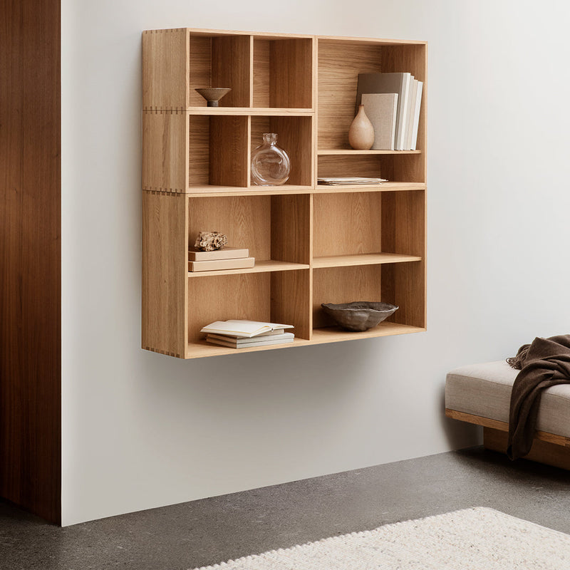 Light oak wall-mounted shelf with a minimalist design, featuring rectangular compartments and a natural wood grain pattern.
