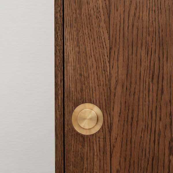 Wooden cabinet door with rich brown grain and a round gold knob, featuring a minimalist white background.