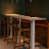 Modern wooden bar stools with white and brown accents, featuring sleek lines and minimalistic design.