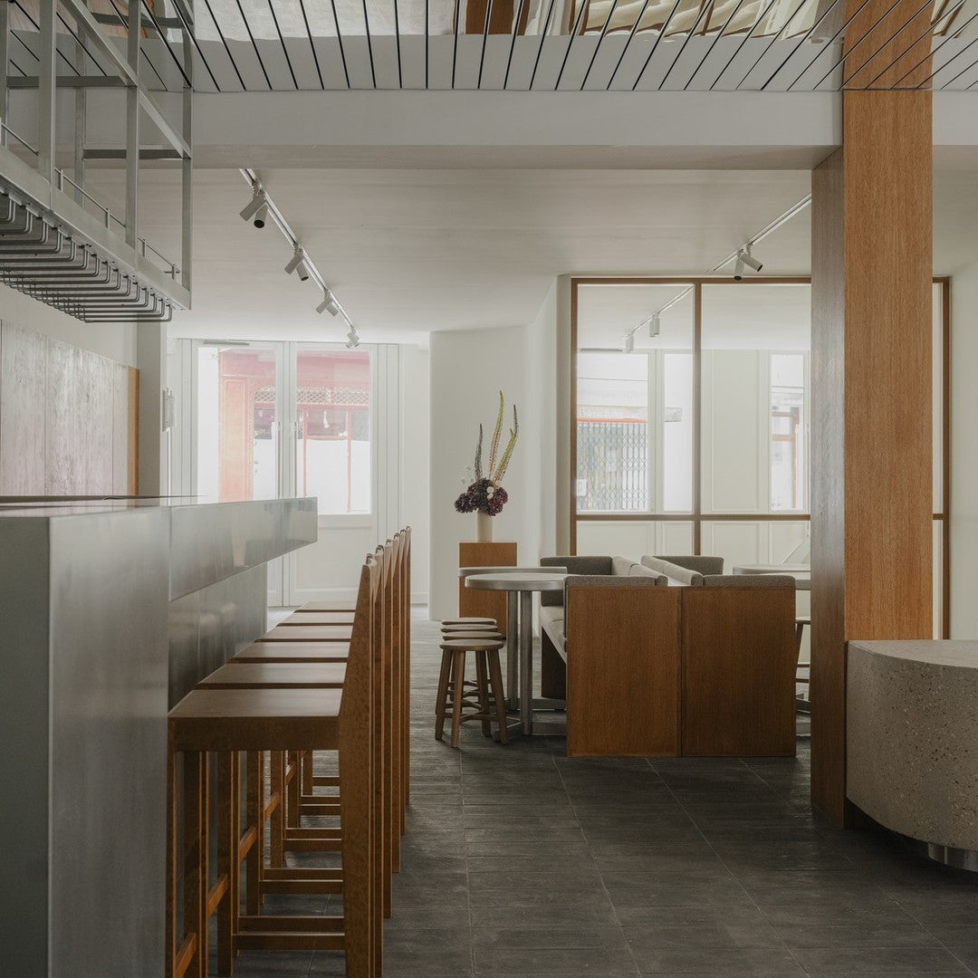 Modern interior with neutral tones, warm wood accents, and a sleek gray floor. Minimalist design elements throughout.