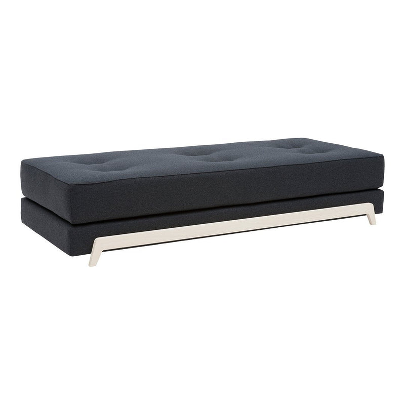 Black tufted sofa upholstered in a sleek fabric, featuring a modern silver base and minimalist design.