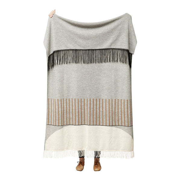 Cozy gray blanket featuring black fringe and subtle striped patterns in beige and cream. Ideal for stylish warmth.