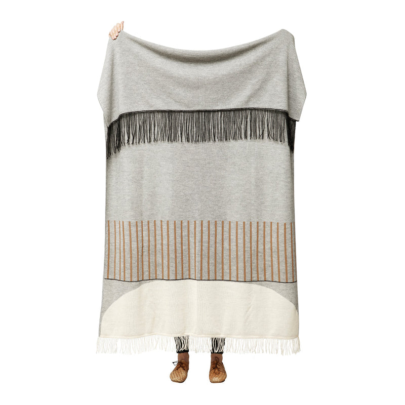 Cozy gray blanket featuring black fringe and subtle striped patterns in beige and cream. Ideal for stylish warmth.