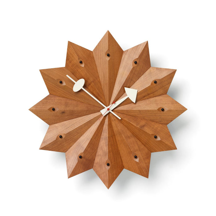 Geometric wooden wall clock in a starburst design, featuring warm brown tones and bold triangular patterns.