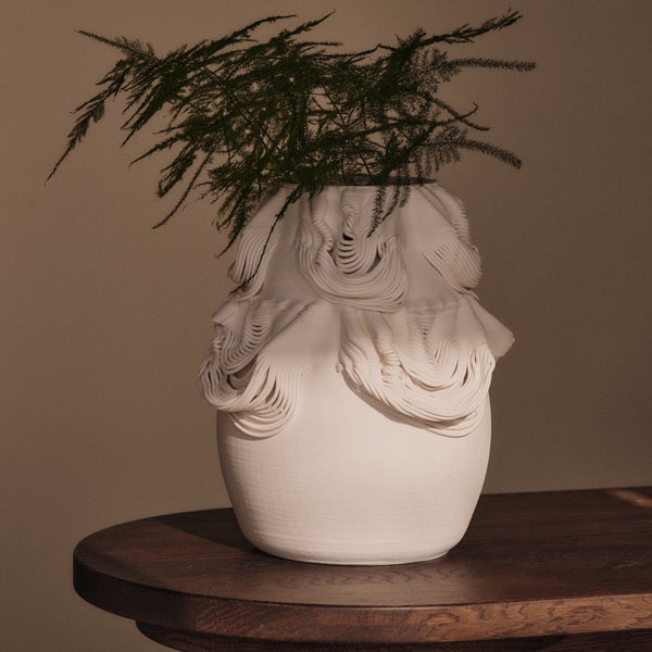 Textured white ceramic vase with intricate wave patterns, showcasing subtle variations in surface detail.