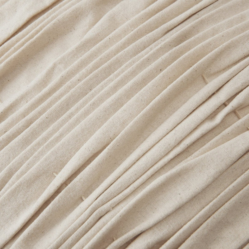 Beige pleated fabric with a textured surface, featuring subtle variations and a natural, organic look.