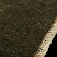 Dark green textured rug with a light beige fringe, showcasing a subtle, cozy pattern. Perfect for any decor.