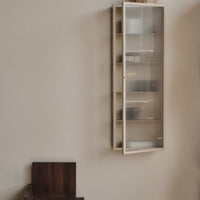 Light cream cabinet with textured glass doors, featuring neutral tones and minimalistic design elements.