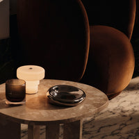 Warm brown tones, soft cream, and sleek metallics on a marbled table, creating a cozy, modern aesthetic.