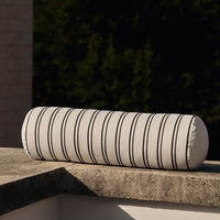 Striped bolster pillow in cream and black, featuring evenly spaced vertical lines for a modern touch.