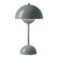 Modern table lamp in soft green with a rounded shade and base, featuring a minimalist design and smooth surfaces.
