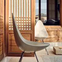 Modern cream chairs with sleek curves, contrasting against natural wood and traditional lattice patterns.
