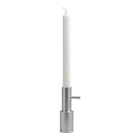 Sleek silver candle holder with a tall white candle, creating a modern, minimalist aesthetic.