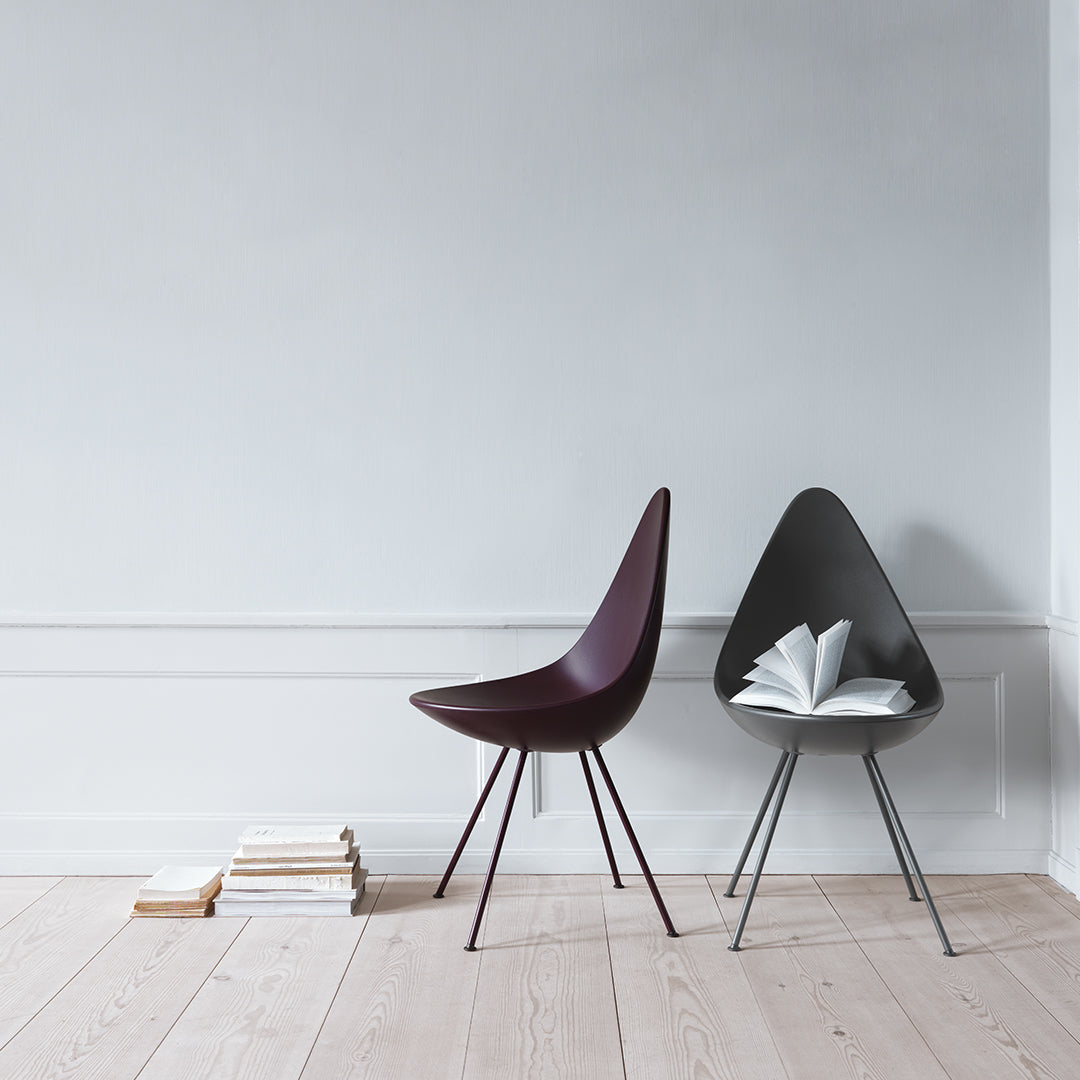 Modern chairs in deep burgundy and sleek black, featuring minimalist designs on a light wooden floor.