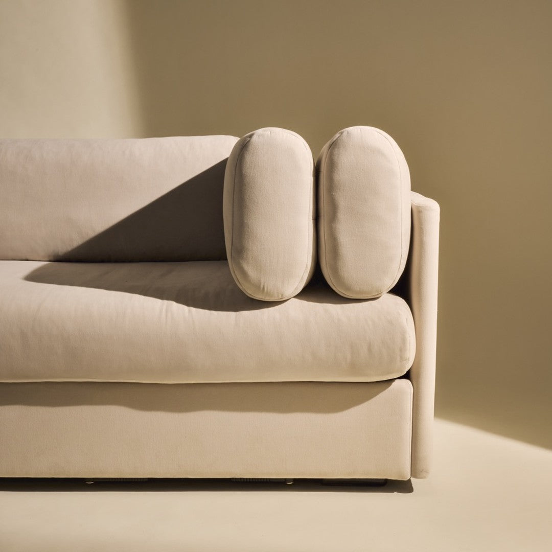 Beige sofa with rounded cushions on a soft, neutral background, showcasing a minimalist and modern design.