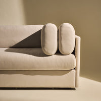 Beige sofa with rounded cushions on a soft, neutral background, showcasing a minimalist and modern design.