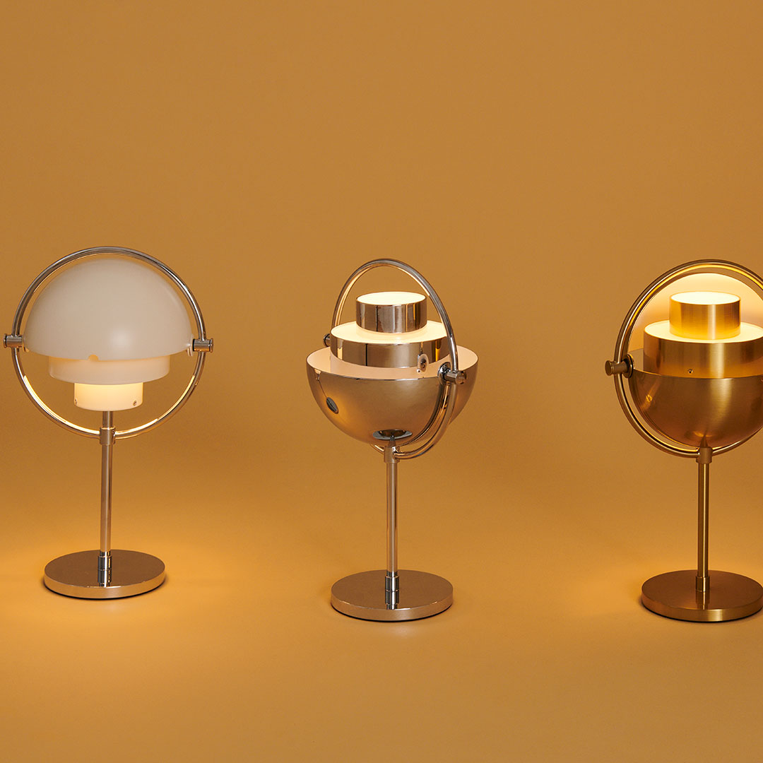Three modern lamps featuring sleek metallic finishes and soft white and gold hues against a warm yellow background.