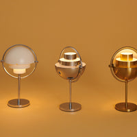 Three modern lamps featuring sleek metallic finishes and soft white and gold hues against a warm yellow background.