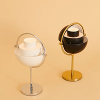 Two modern lamps in white and black with silver and gold accents against a soft beige background.