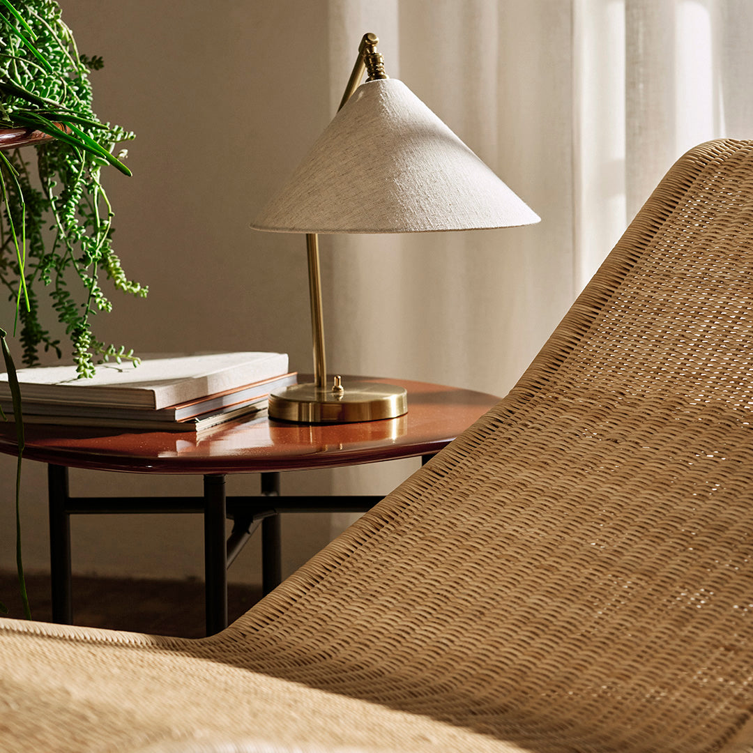 Natural woven textures in beige, paired with a soft white lamp and rich wooden table accents.