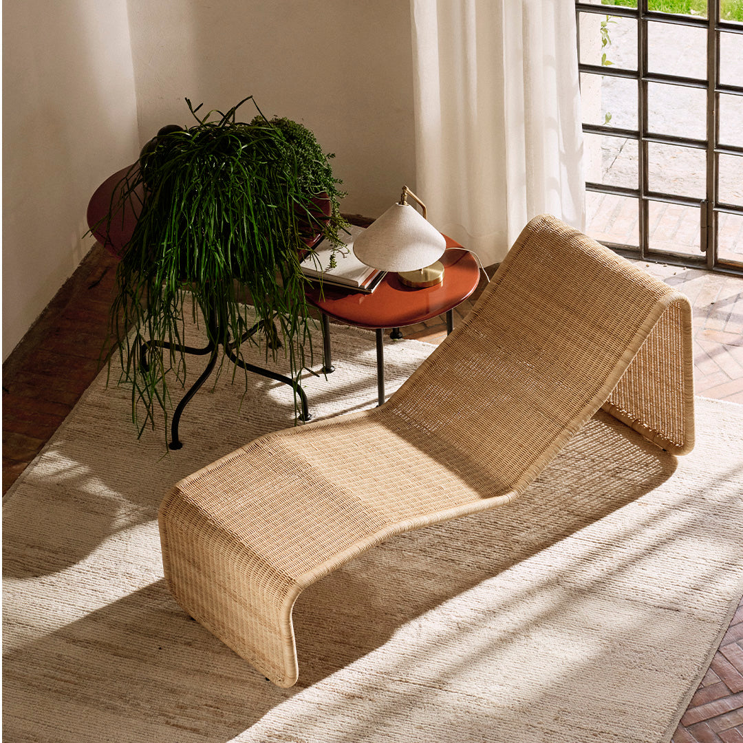 Natural woven rattan chaise lounge in light beige, showcasing a sleek, modern design with soft curves.