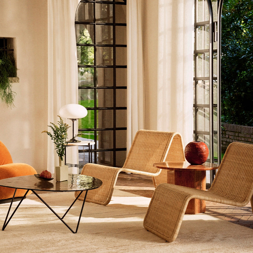"Stylish living room featuring orange, natural wood, and neutral tones with woven patterns and sleek black accents."