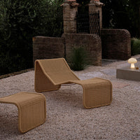 "Beige outdoor lounge chairs with a textured pattern, set against a rustic stone backdrop in a tranquil garden."