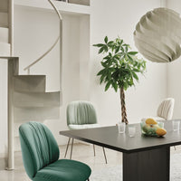 Elegant green and pastel chairs against a light backdrop, featuring minimalist patterns and textures in a modern setting.