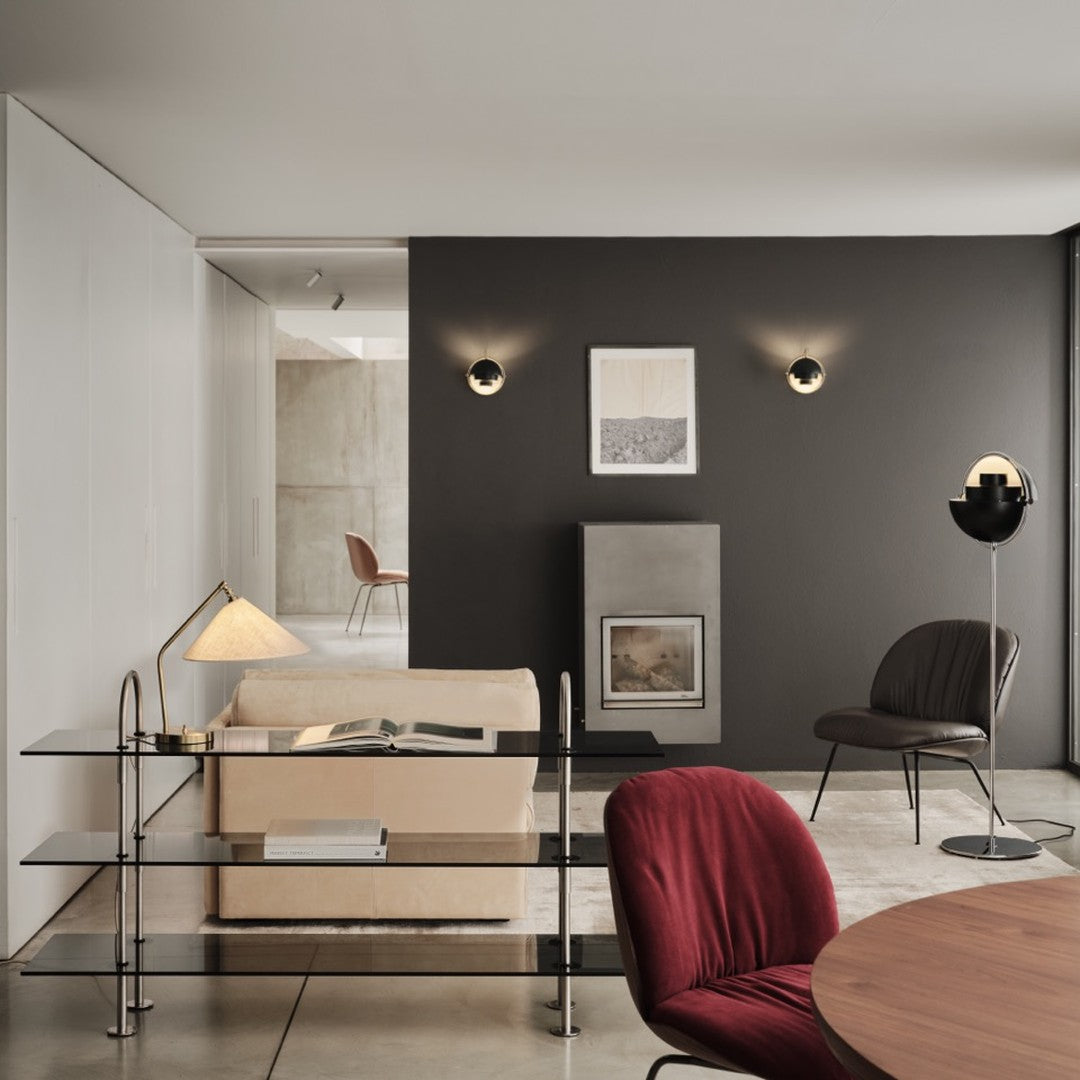 Modern interior with beige sofa, burgundy chair, black accents, and neutral walls creating a sleek, minimalist aesthetic.