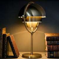 Elegant black and gold desk lamp featuring a sleek, modern design with a circular shade and warm lighting.