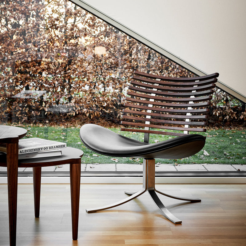 Modern chair featuring a sleek black leather seat, striped wooden backrest, and a polished metal base. Natural light ambiance.