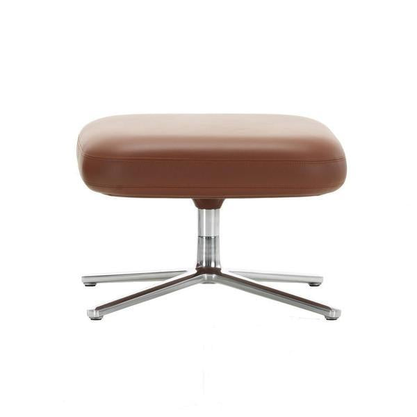 Brown leather ottoman with smooth surface and a sleek chrome base, perfect for modern interiors.