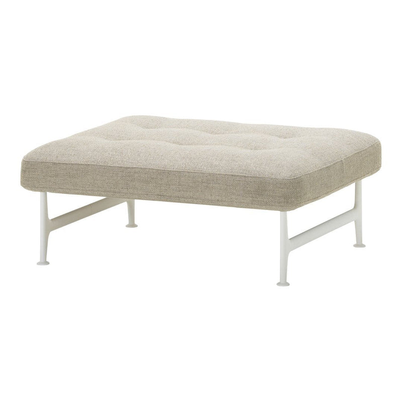 Light beige upholstered ottoman with tufted pattern and sleek white legs, perfect for modern decor.