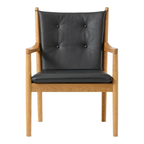 Modern chair featuring a sleek black leather seat with button tufting and natural wood arms and legs.
