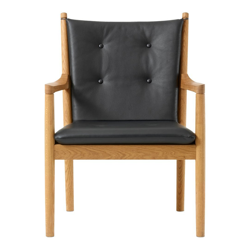 Modern chair featuring a sleek black leather seat with button tufting and natural wood arms and legs.