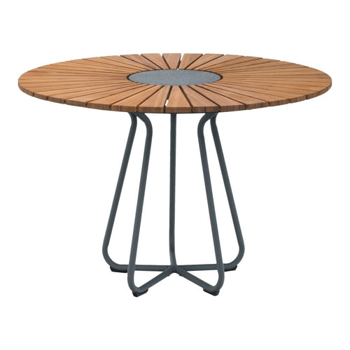 Round wood dining table with a natural wooden slat pattern and a dark metal base, perfect for modern outdoor spaces.