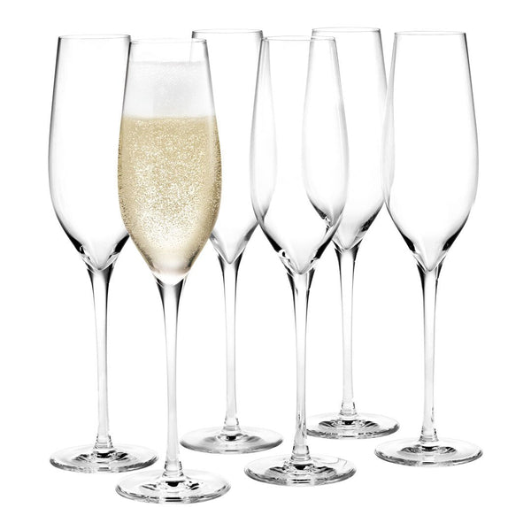 Set of six elegant, clear glass champagne flutes with one filled, showcasing bubbles against a minimalist background.