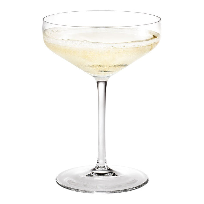 Clear glass coupe with a slender stem, featuring sparkling pale champagne liquid inside. Elegant and minimalist design.