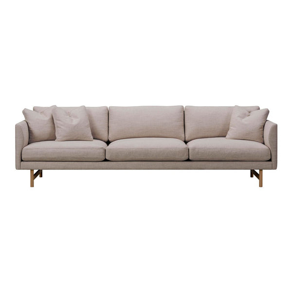Light beige sofa with smooth fabric and subtle texture, featuring clean lines and minimalist design, adorned with plush pillows.