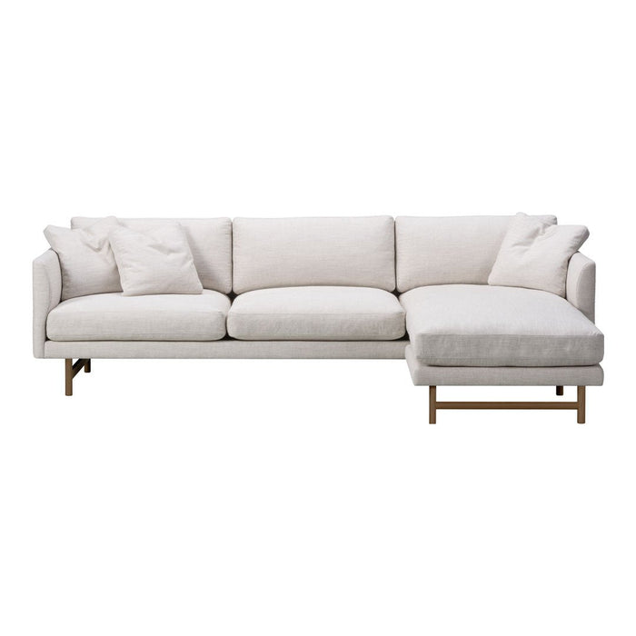 Light beige sectional sofa with soft, textured fabric and minimalist design, featuring subtle patterns and modern brass legs.