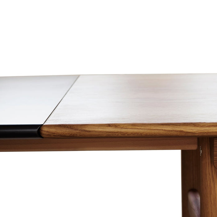 "Light wood dining table with a split surface featuring a smooth white finish and dark edge detail."