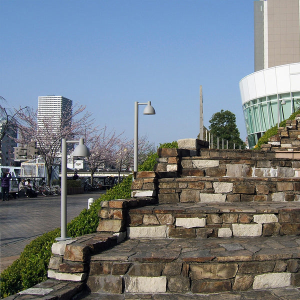 Textured stone steps with varied gray and white hues, accented by green grass and bright blue sky.
