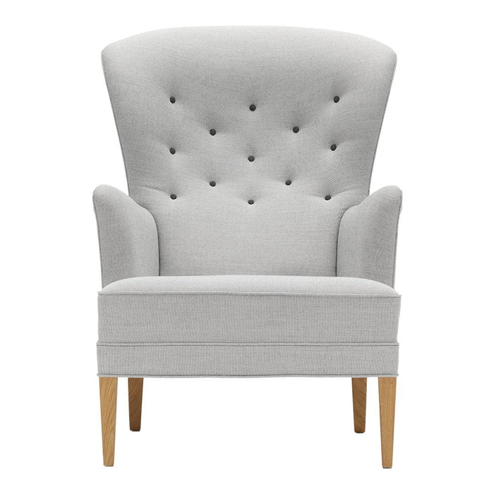 Light gray upholstered chair with tufted back and wooden legs, featuring a sleek, modern design.