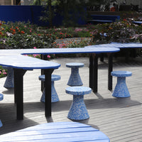 Blue and patterned outdoor furniture set with unique shapes against a vibrant floral backdrop.