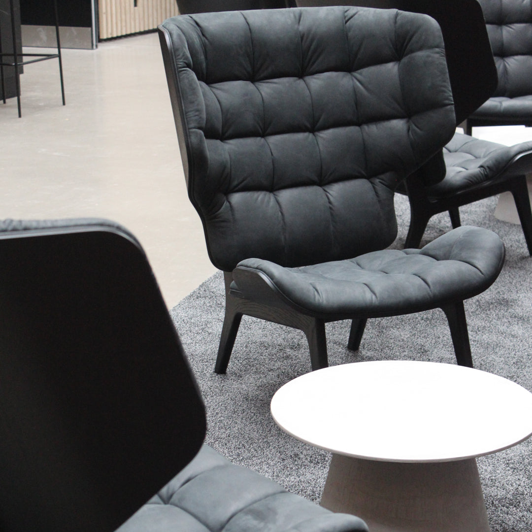 "Stylish dark gray upholstered chair with a quilted pattern, set against a neutral backdrop."