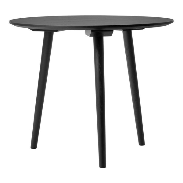 Black round table with sleek, minimalist design and three tapered legs, perfect for modern decor.